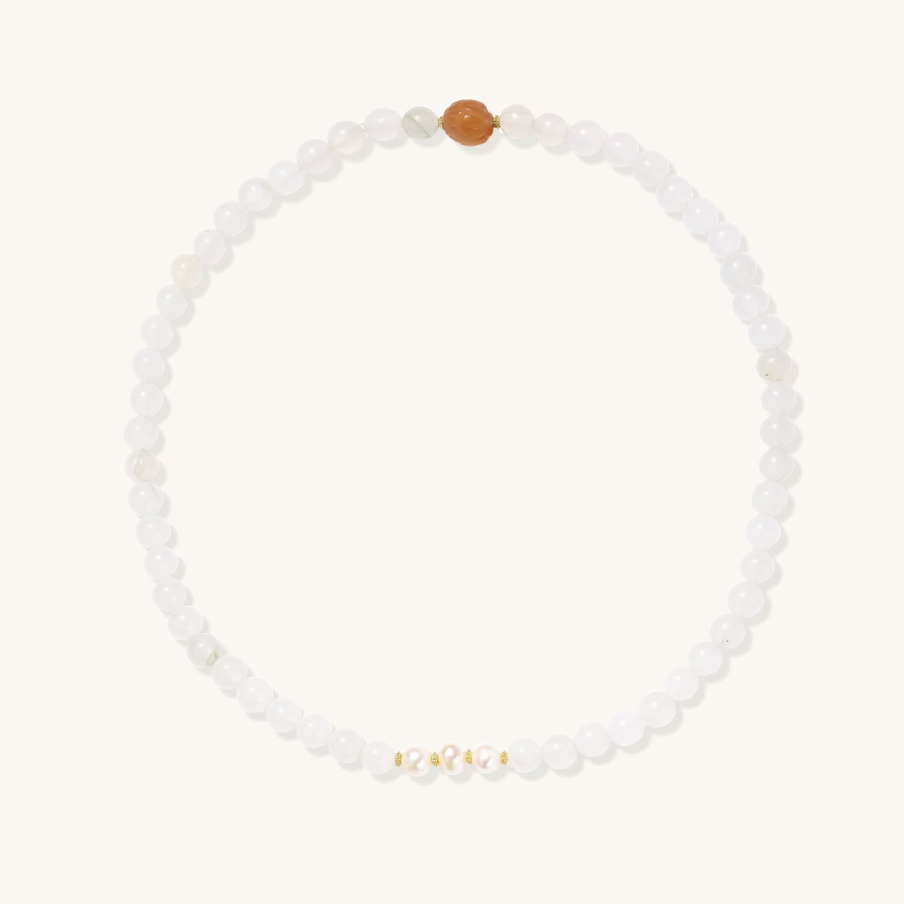 Stretch bracelet with white jade beads, freshwater pearls, and orange agate centerpiece on cream background.