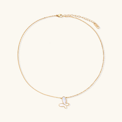 Delicate gold butterfly necklace with white mother of pearl wings on fine chain, displayed on neutral background.