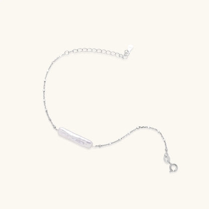 Minimalist bracelet with iridescent baroque pearl on rhodium-plated sterling silver chain against cream background